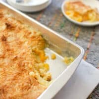 Close up of pineapple orange dump cake with coconut in a serving pan on a table.