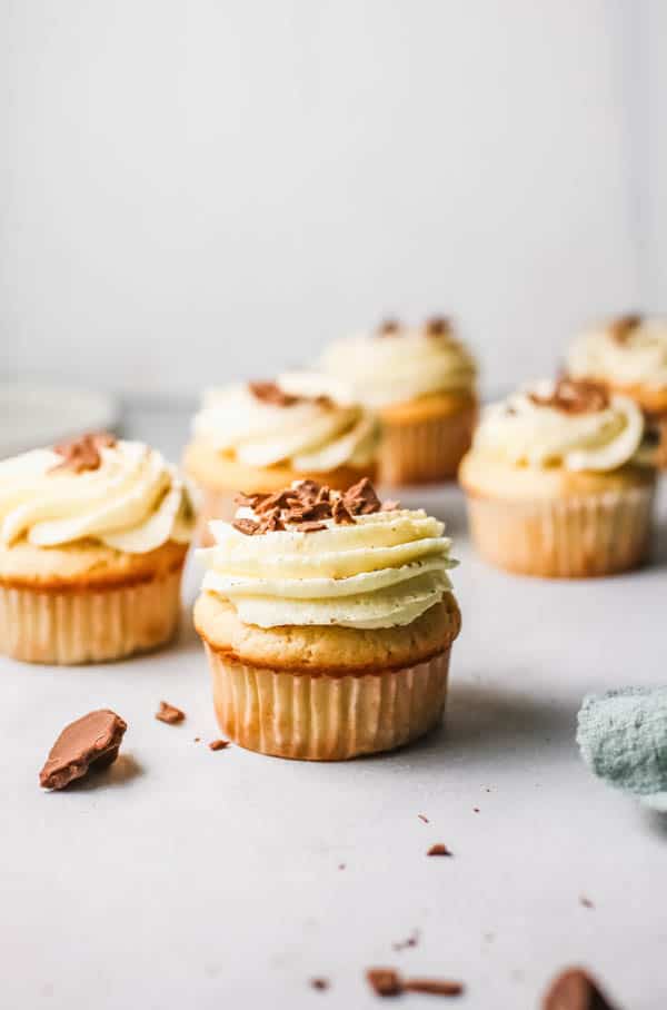 Batch of frosted White Russian cupcakes infused with vodka on a table.