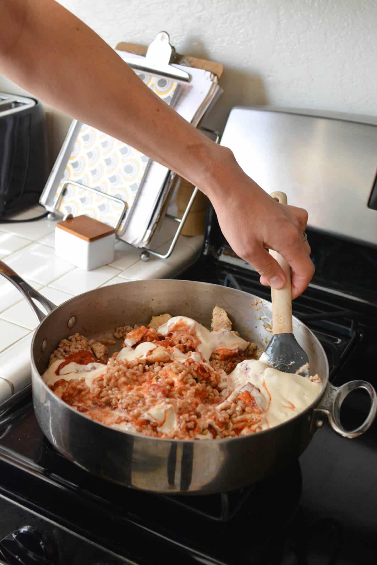 Man stirring a pan on the stovetop.