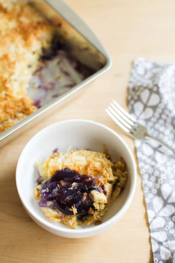 A serving of blueberry and pineapple dump cake on a wooden cutting board