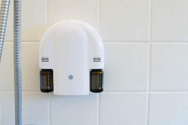 Shower diffuser for essential oils attached to a wall.