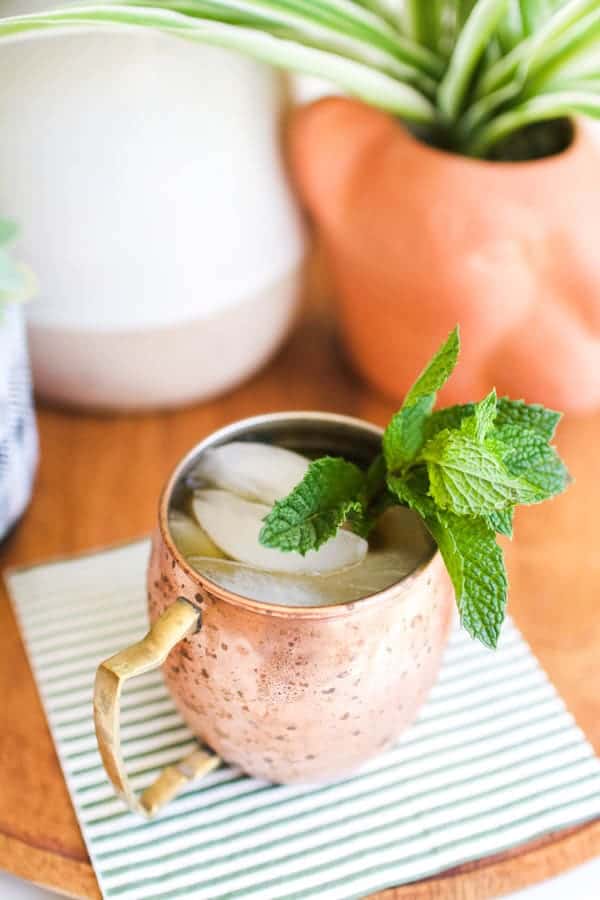 Rum mule in a copper Moscow Mule mug on a striped napkin.