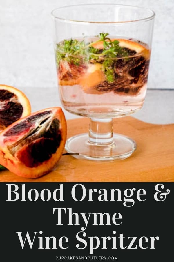 A wine glass holding a white wine spritzer with blood orange pieces and thyme with text over it.