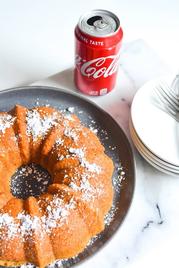 easy coke cake recipe on a plate next to a can of coke