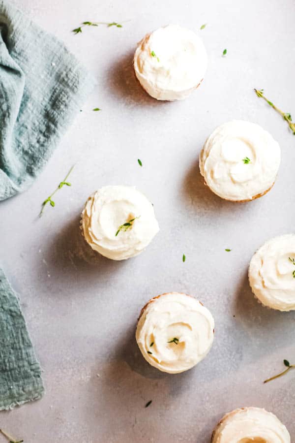 Lemon buttercream frosted St. Germain elderflower cupcakes on a table.