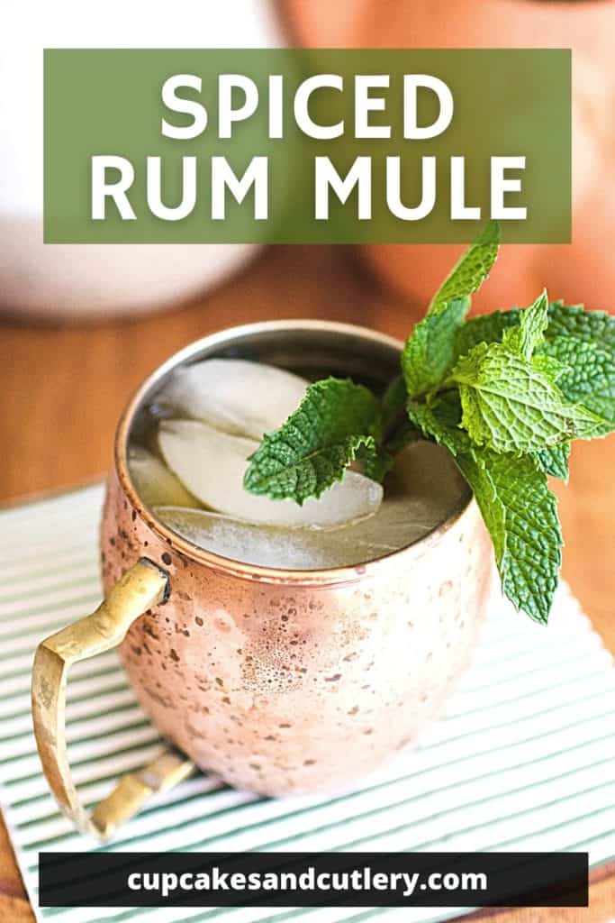 Spiced Rum Mule cocktail in a copper mule mug garnished with fresh mint on a triple cocktail napkin.