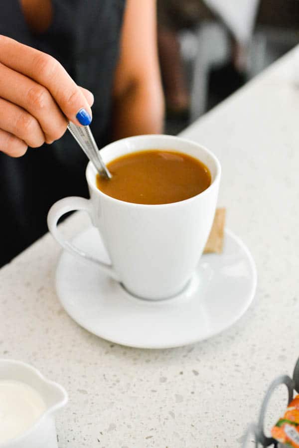 Woman stirring a cup of coffee.