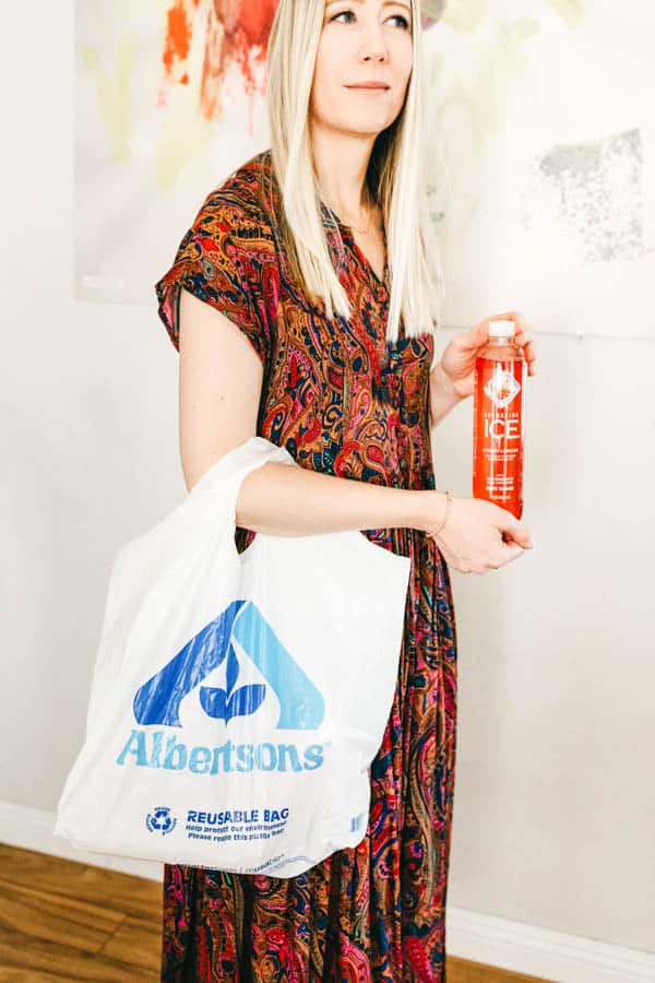 Woman with Albertsons bag on her arm holding a Sparkling Ice.