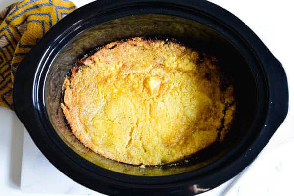 Cake batter crust on top of an apple dump cake cooked in a crockpot
