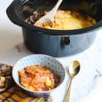 apple dump cake in a crockpot with a serving next to it