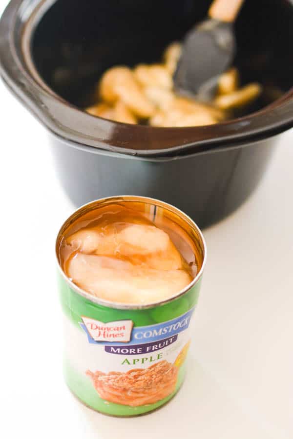 An open can of apple pie filling next to the bowl of a slow cooker