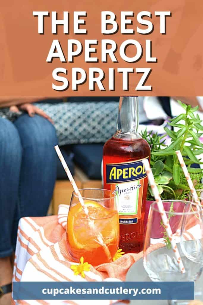 An Italian Spritz on a table next to a bottle of Aperol.