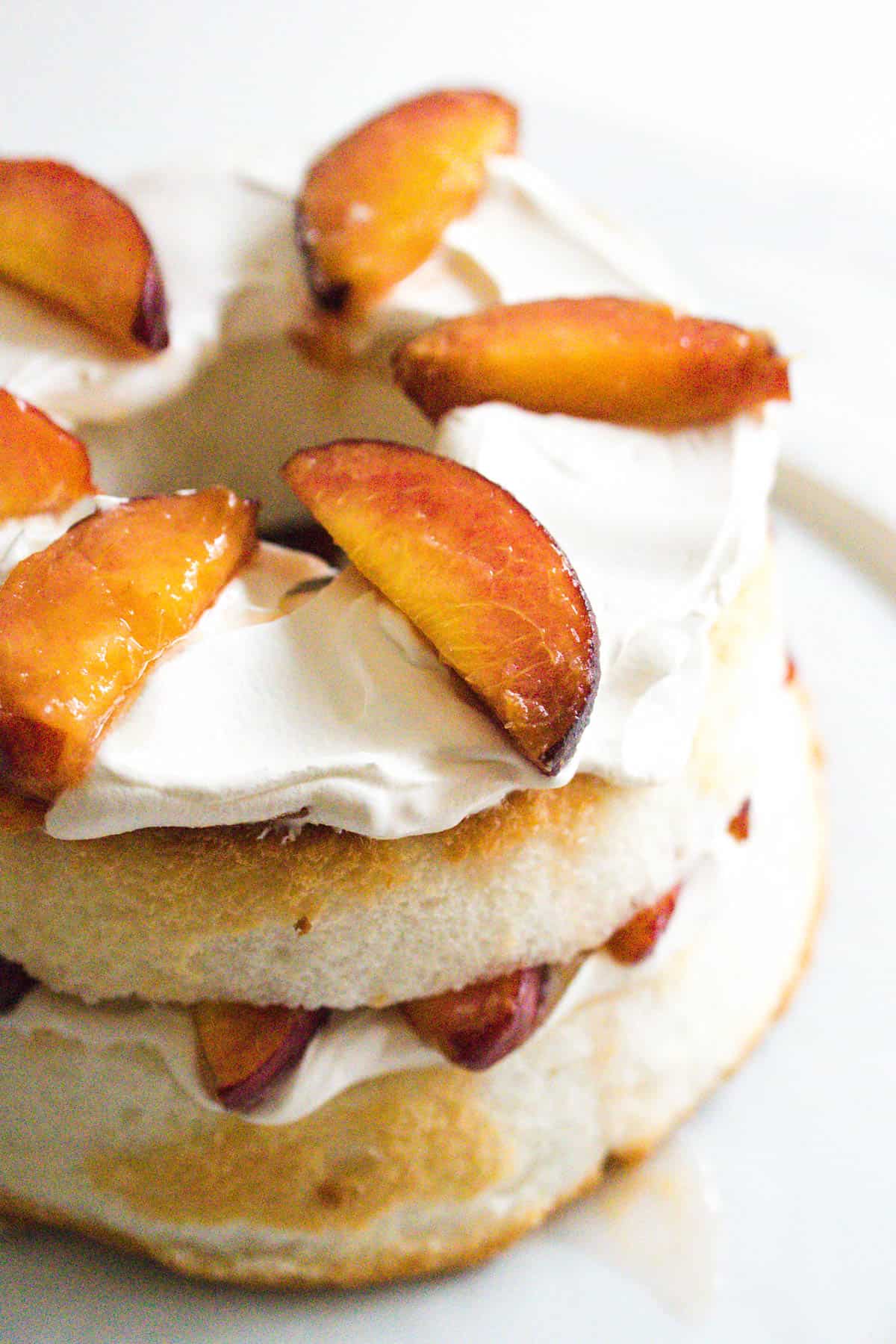 Layered angel food cake with Cool Whip and peaches stacked into a dessert.