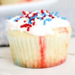 Close up of a frosted cupcake with red, white and blue sprinkles.