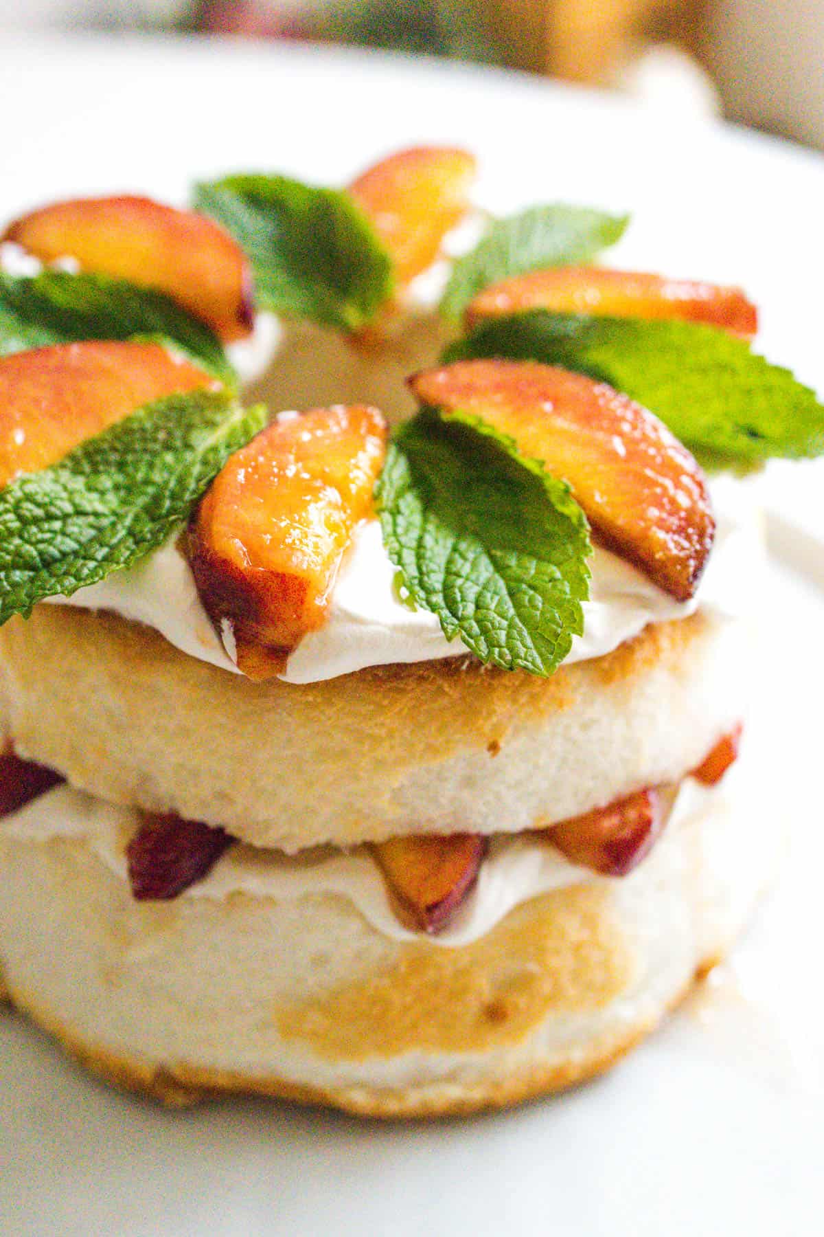 Fresh mint and peaches on top of an angel food cake.