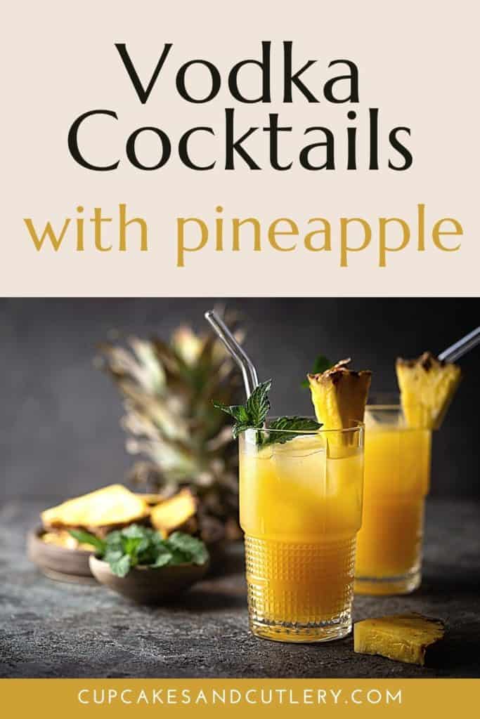 Two bright vodka cocktails with pineapple juice in front of pineapple slices and fresh herbs.