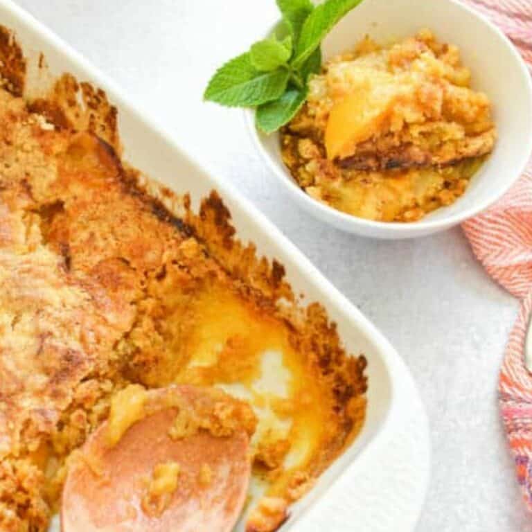 Close up of a peach dump cake being served into white bowls.