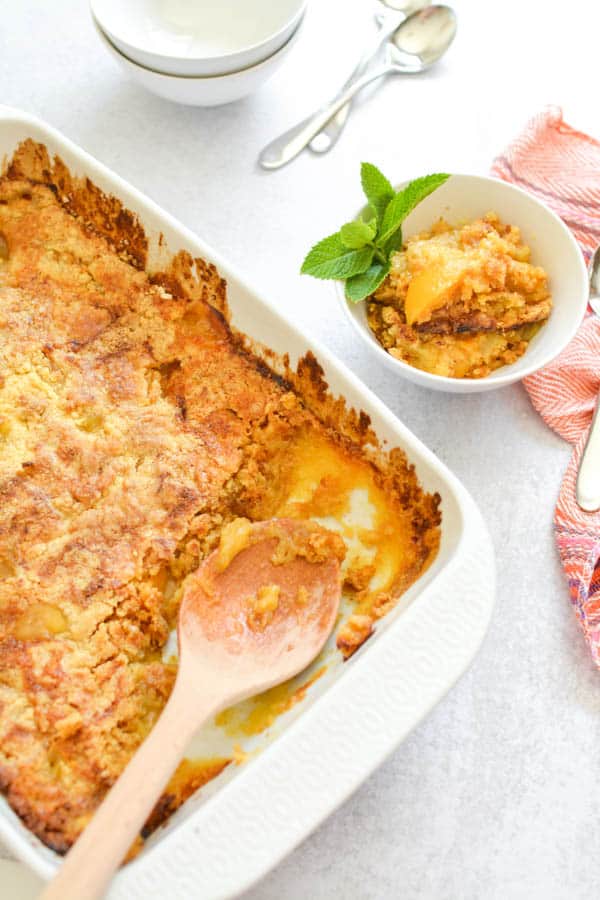 Peach dump cake in baking dish and small plate.