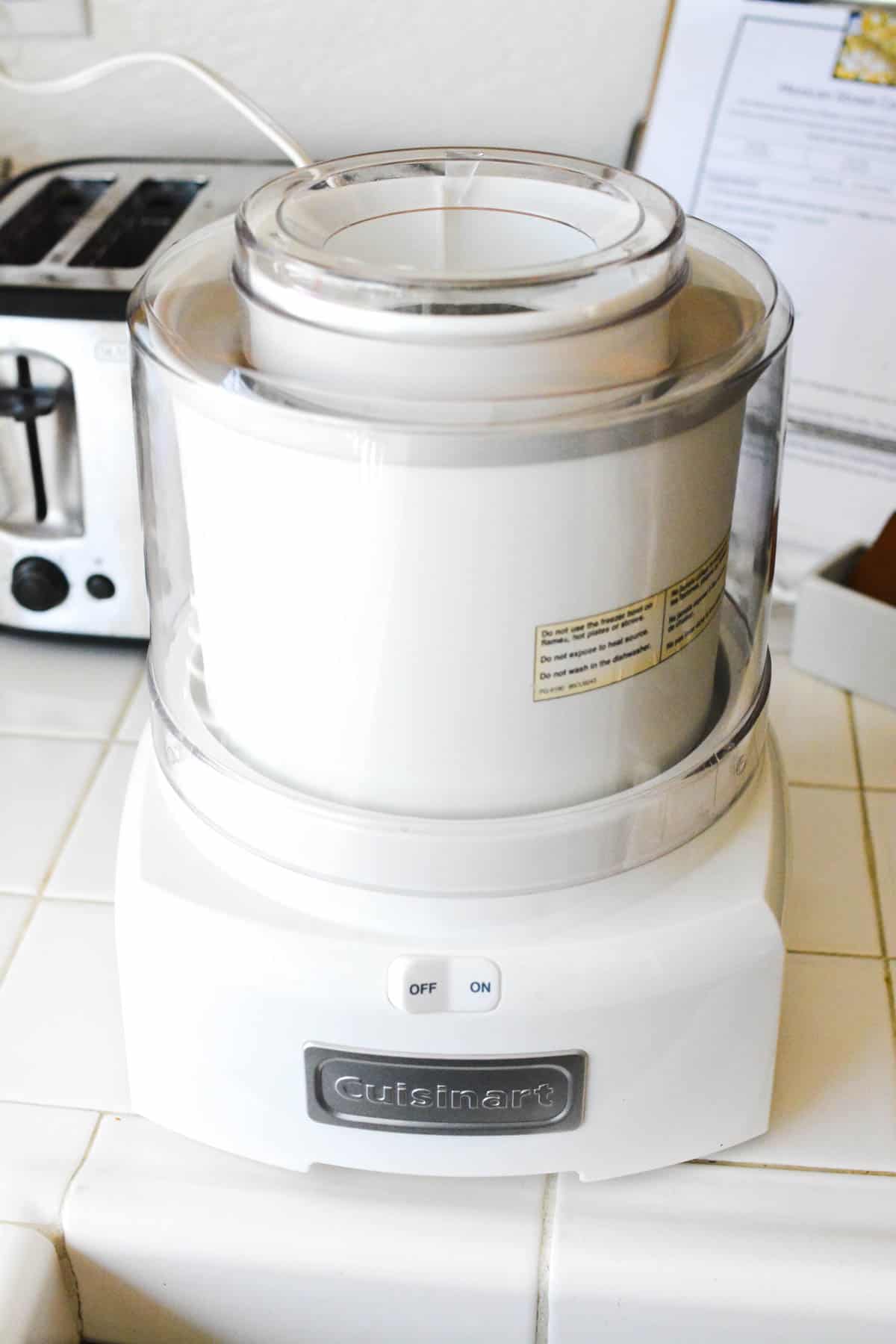 A Cuisanart ice cream maker on a counter.