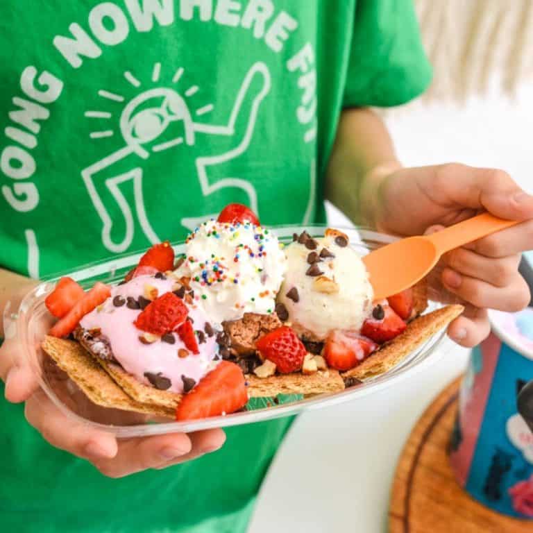 Kid holding a tray of ice cream nachos.