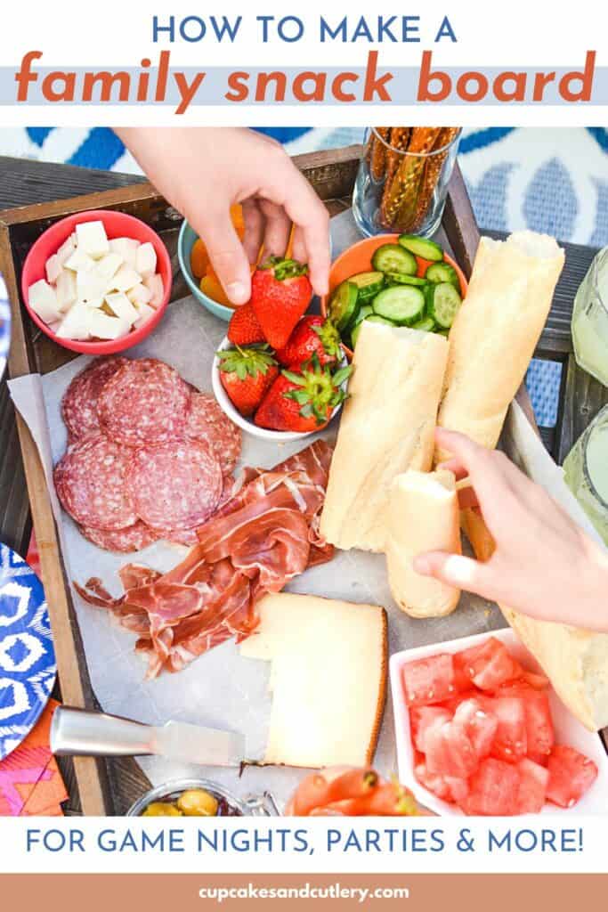 Text: How to make a family snack board; on top of an image of people taking food from a snack platter.