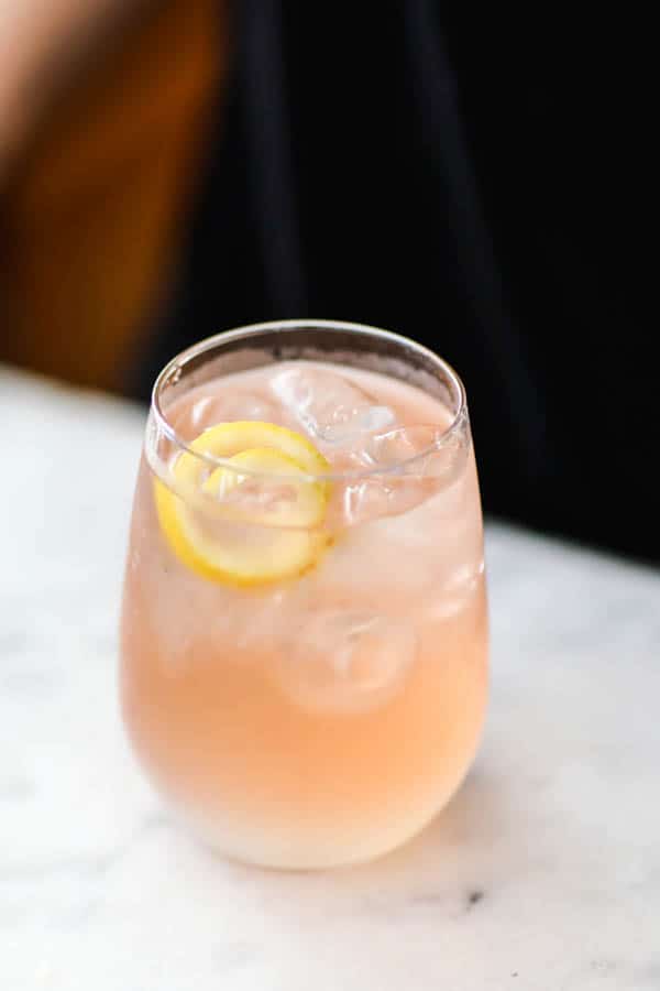 A close up of Rose Lemonade Spritzer spiral made out of a piece of lemon peel.