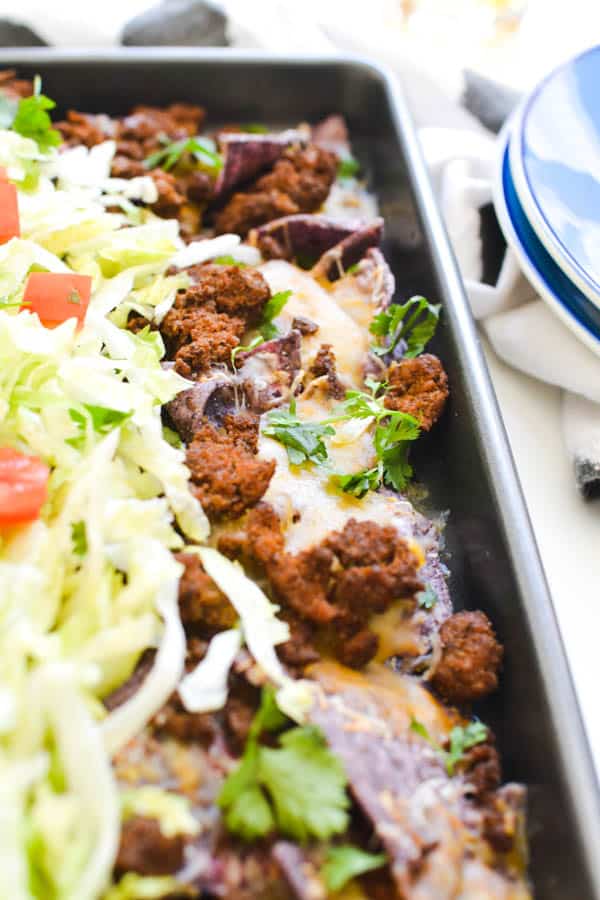 Delicious nachos with blue corn tortilla chips and ground taco meat.