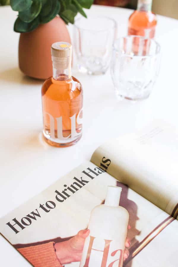 Bottles of Haus on the table next to a magazine about the aperitif brand.