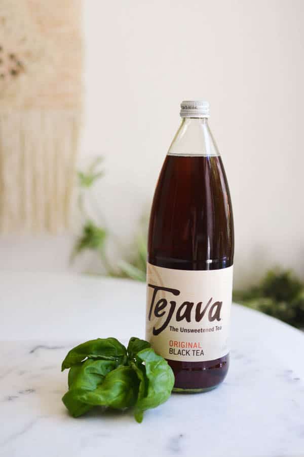 Bottle of Tejava tea and fresh basil on a cutting board.