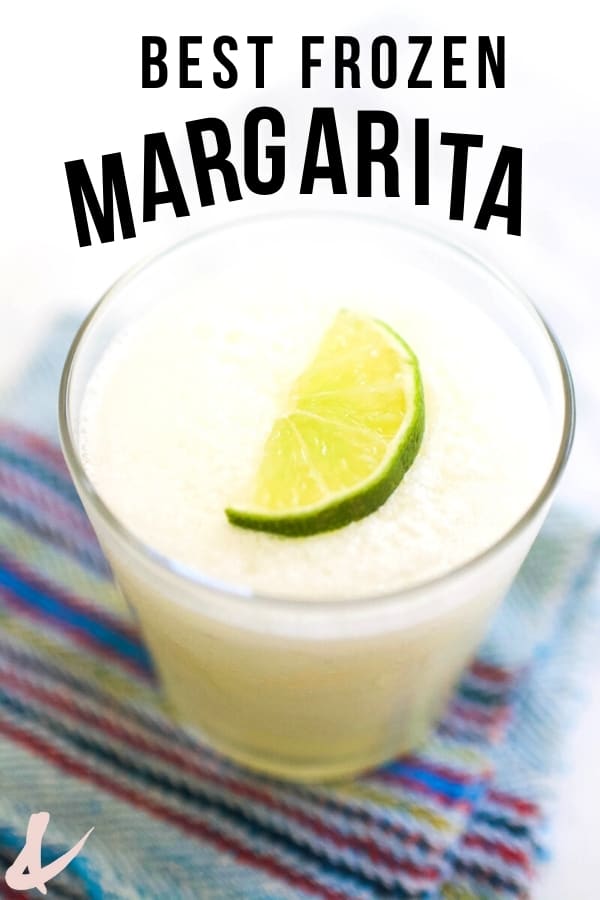 Glass with best frozen margarita recipe with lime on top.