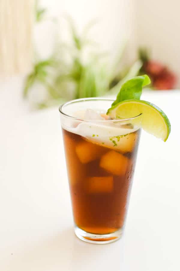 Shaken iced tea with fresh basil in a glass.
