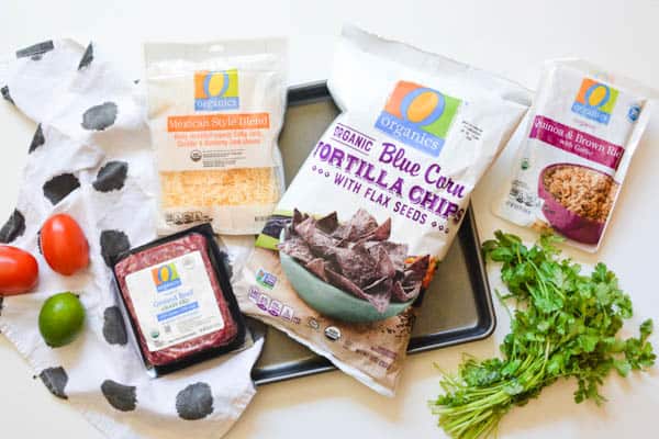 Ingredients for sheet pan nachos with ground beef, blue corn tortillas and shredded cheese. 