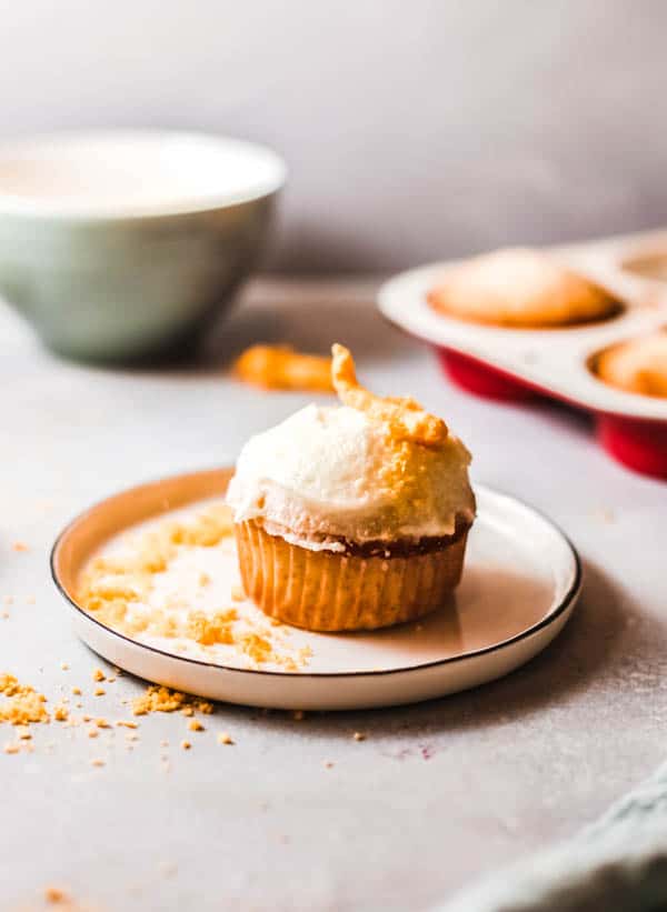 Cream cheese topped cupcakes with Cheetos on a plate.