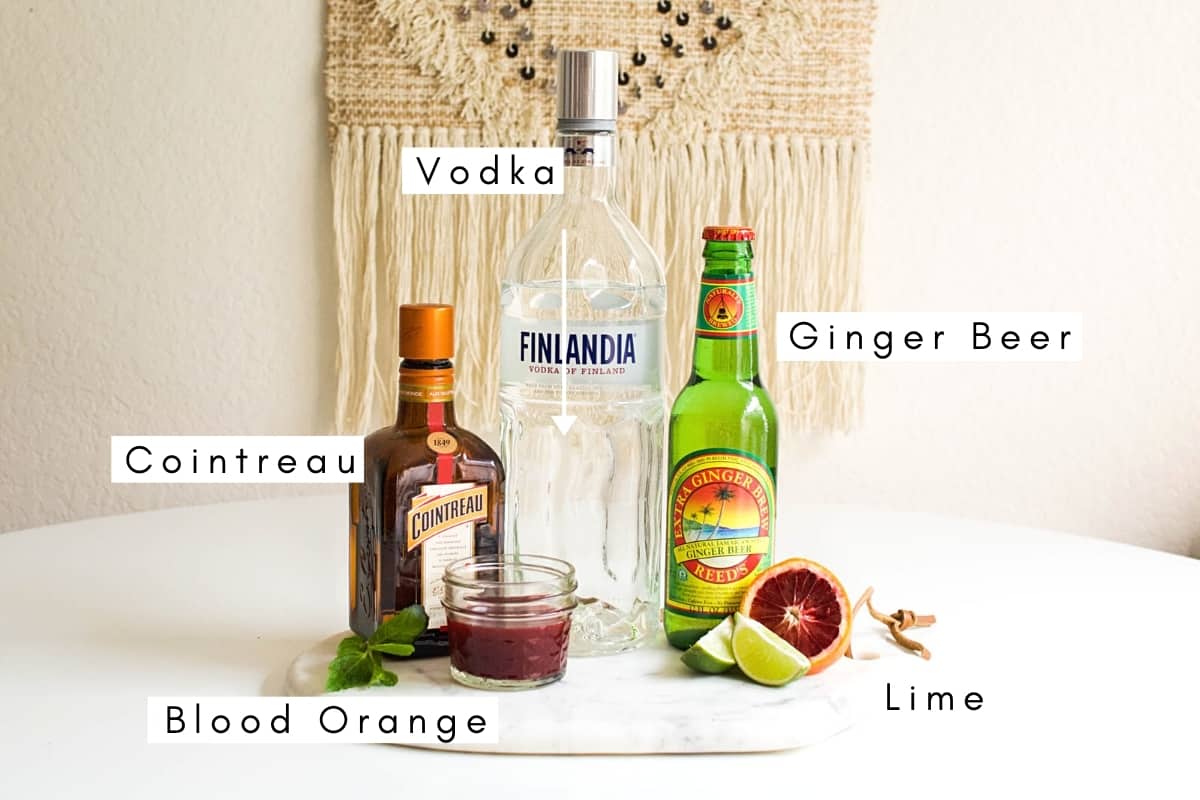 Labeled ingredients to make a blood orange Moscow Mule cocktail.