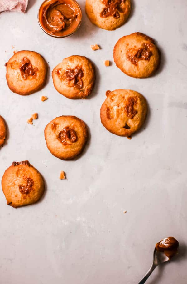 Baked cookies laid out on a table next to butterscotch chips.