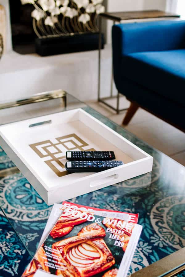 Coffee table with tray, remote controls and magazine.