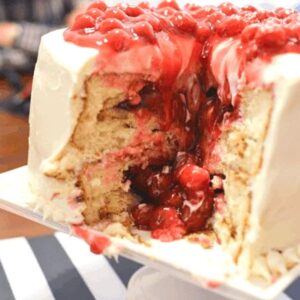 Two layer cake with cherry pie baked into each layer and a big slice removed so we can see the inside.