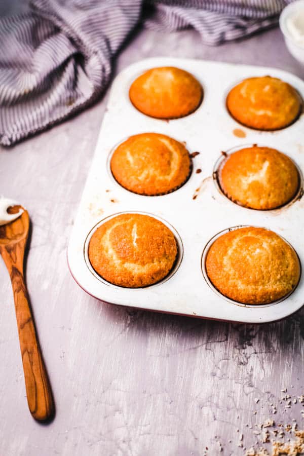 Baked cupcakes in a muffin tin on a table.