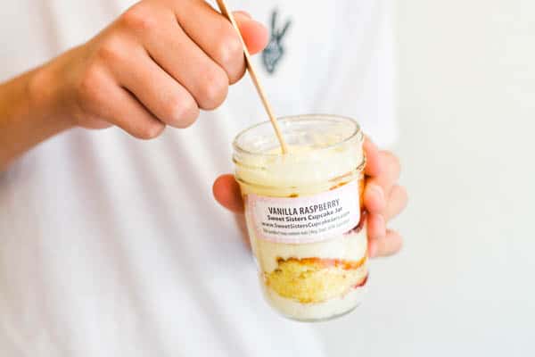 Kid using a fork to eat a cupcake in a jar.