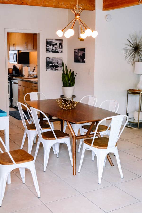 View of dining table and galley kitchen behind it in Palm Springs rental home.