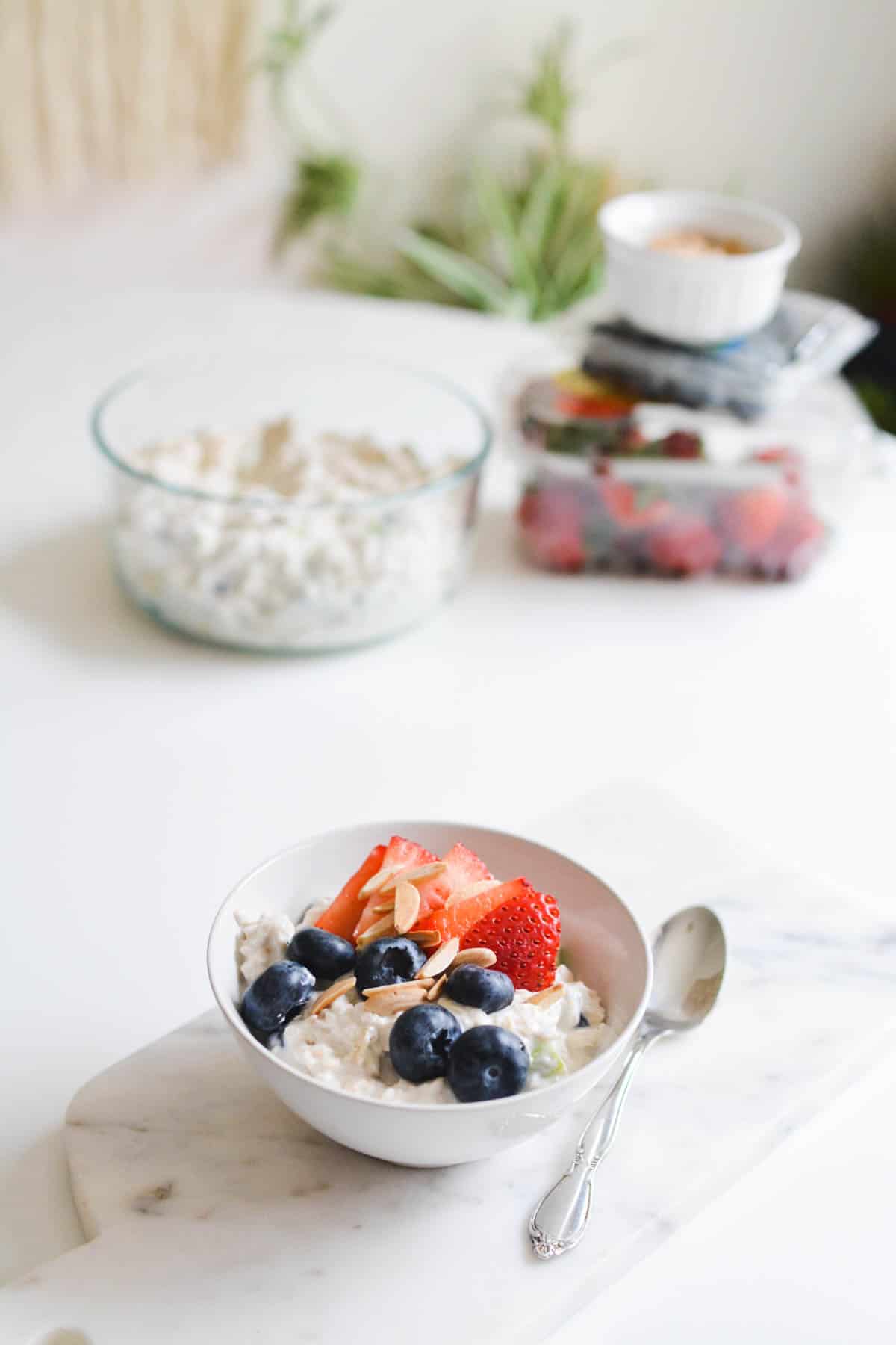 A bowl of cold oatmeal topped with fresh berries with and almonds.