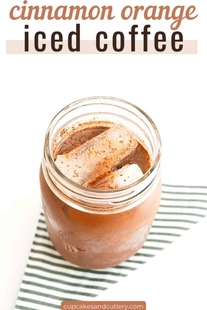 Text - Cinnamon Orange Iced Coffee over an image of a jar holding iced coffee topped with fresh nutmeg.