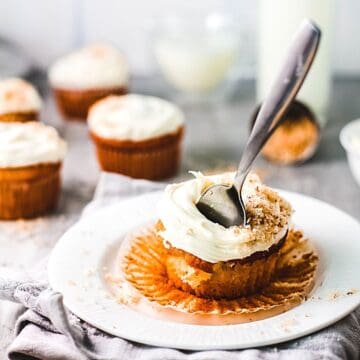 A Coconut Rum Cupcakes on a plate with a fork sticking out of it.