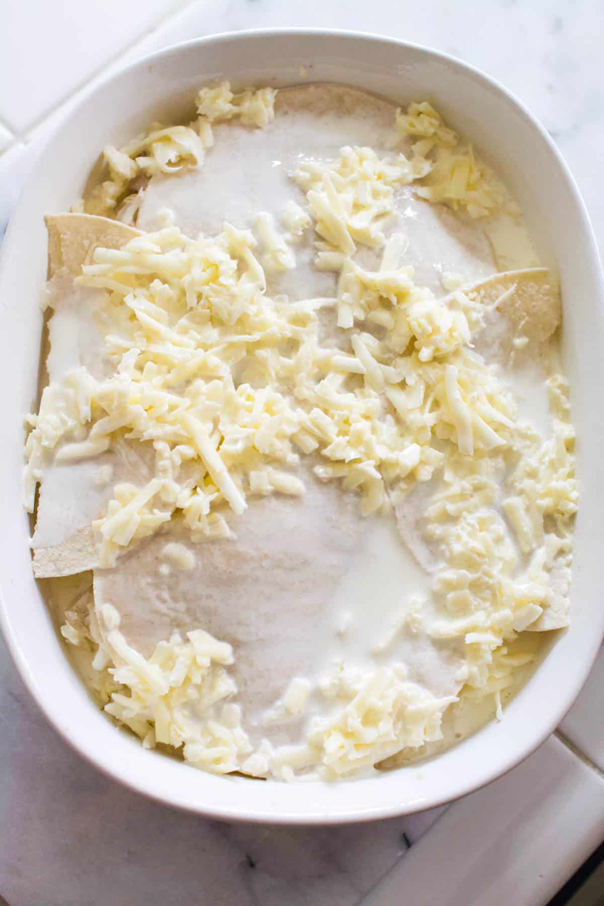 Overhead view of a baking dish with a casserole covered in cream sauce.