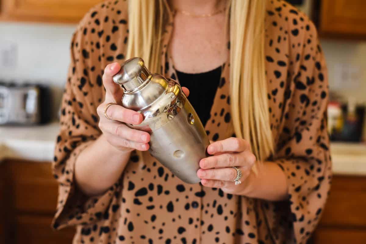 Woman holding a cocktail shaker.