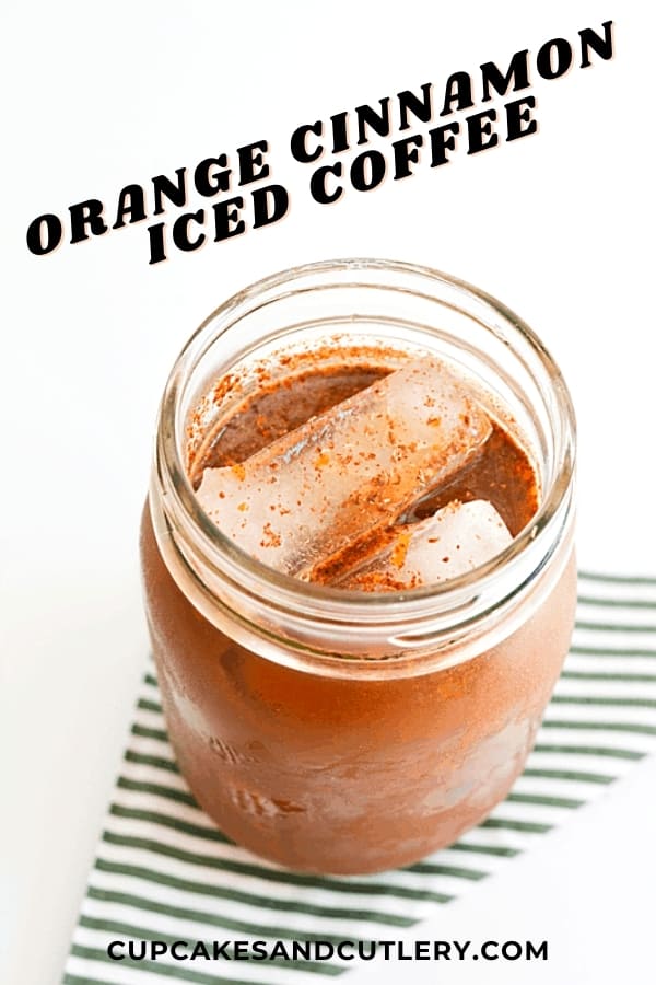 Close up of a jar holding iced coffee on a striped napkin.