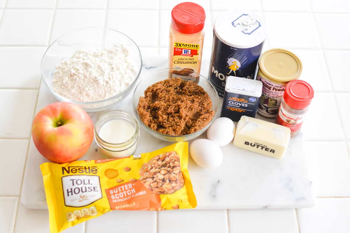 Ingredients for apple cookies laid out on a white tiled counter.
