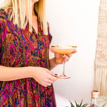 Woman holding a coupe glass with a Spiced Rum Daiquiri in it.