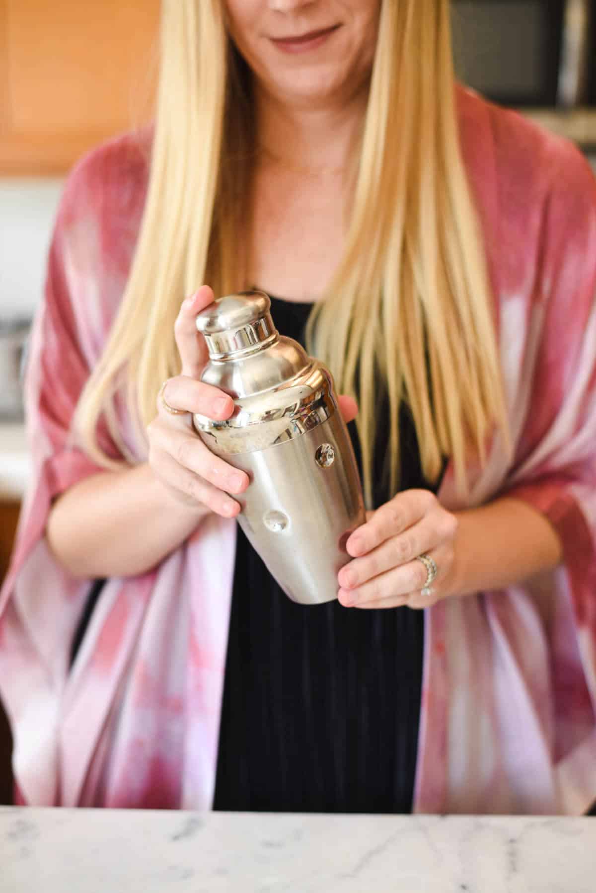 Woman holding cocktail shaker.