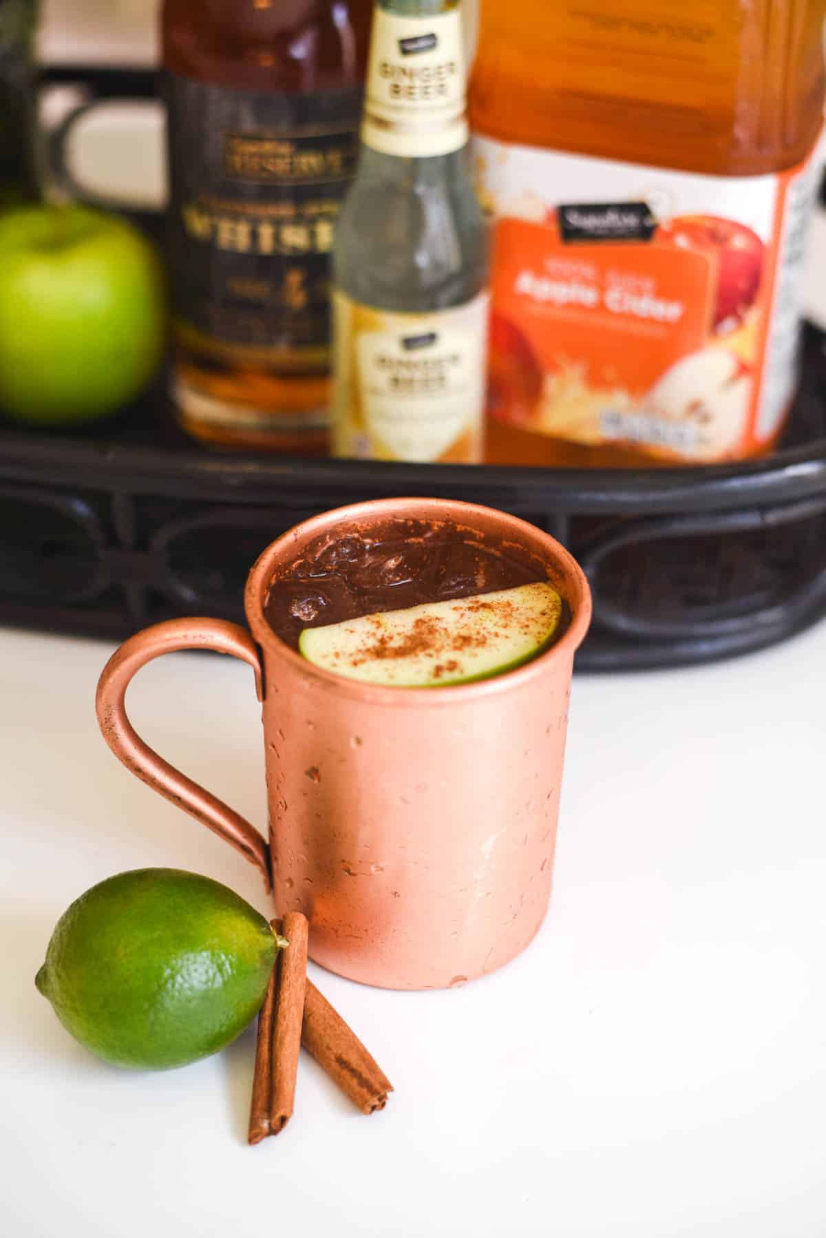 Close up of a copper Moscow Mule mug with an apple garnish.